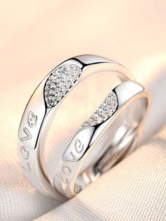 two white gold wedding rings with diamonds on top and the words love written in silver