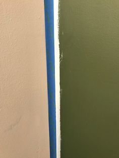 the wall is painted green and white with some blue tape on it's side