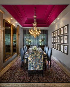 the dining room is decorated in rich colors and features an elaborate chandelier that hangs from the ceiling