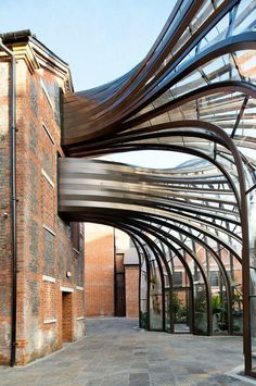 the walkway is lined with metal and brick arches, which are connected to each other