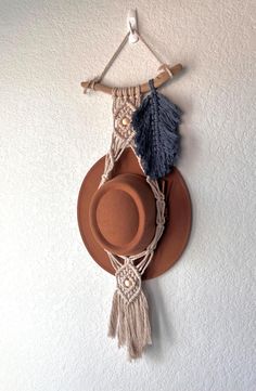 a hat hanging on the wall with some tassels