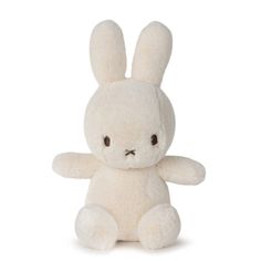 a white stuffed rabbit sitting up against a white background