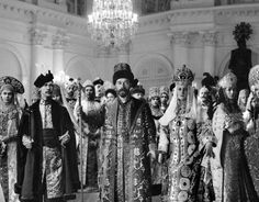 an old black and white photo of some people dressed in elaborate clothing, standing next to each other