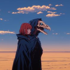 a person standing in front of a large dinosaur head with red hair and a black cape