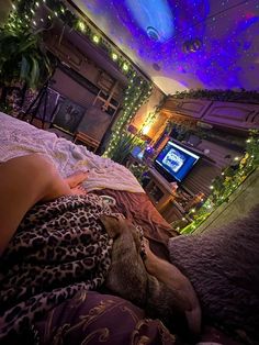 a woman laying on top of a bed next to a tv