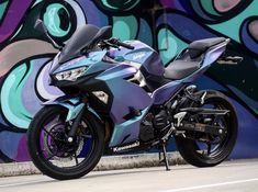 a motorcycle parked in front of a graffiti covered wall