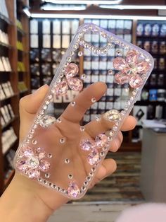 a person holding up a clear case with lots of diamonds on the front and sides