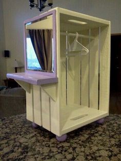 a room with a white and pink display case on it's side, in the middle of a carpeted floor