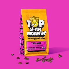 a bag of top of the morning coffee next to some coffee beans on a pink background