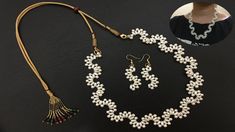 a necklace and earring set with pearls, beads and tassels on a black surface