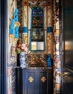 an ornately decorated room with blue and gold decor on the walls, mirrors and cabinets