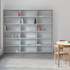 a table and chairs in front of a book shelf