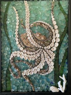 an octopus made out of sea glass and shells on the bottom is surrounded by other seashells