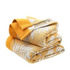 three blankets folded on top of each other in different patterns and colors, one yellow