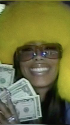 a woman in yellow wig and glasses holding money