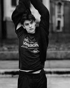 black and white photograph of a young man holding his hands above his head