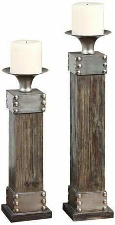 two metal and wood candlesticks with white lamps on each candle holder in the middle