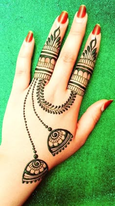 a woman's hand with henna tattoos on it