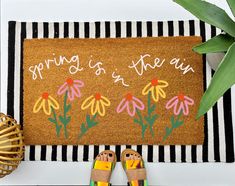 someone is standing in front of a door mat that says spring is in the air