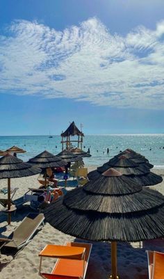 many umbrellas and chairs on the beach