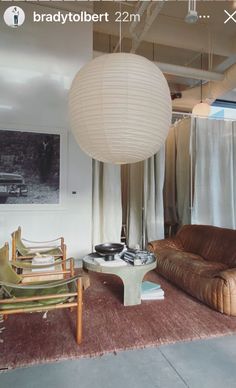 a living room filled with furniture and a large white ball hanging over the top of it