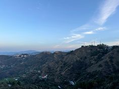 a view of the hills and valleys from atop a hill with houses on top in the distance