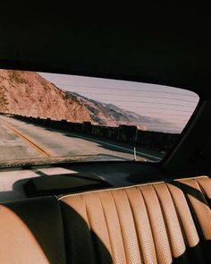 the view from inside a car looking out at mountains and road with no cars on it