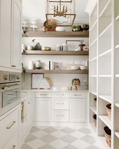 an image of a kitchen with white cabinets and open shelvings on the wall