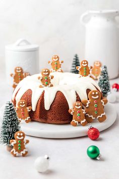 gingerbread bundt cake with icing and christmas decorations around it on a white plate