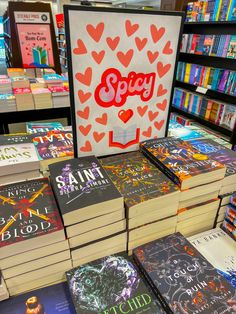 many books are stacked on top of each other in front of a sign that reads sorry love