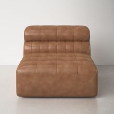 a brown leather couch sitting on top of a white floor