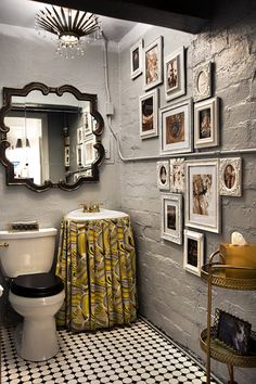 a white toilet sitting next to a bathroom sink under a mirror on top of a tiled floor