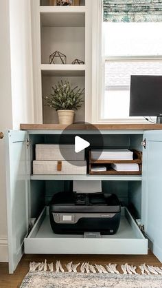 an open cabinet with a computer and printer in it