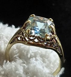 This stunning ring is a one-of-a-kind piece that features a beautiful aquamarine gemstone set in a 14k yellow gold filigree setting. The ring is adorned with a radiant cut aquamarine stone that has a total carat weight of 2. The vintage ring is from the Art Deco era (1915-1935) and is perfect for any occasion, such as an engagement, wedding, anniversary, or graduation. The rare ring is handmade and has a unique style that is perfect for those who appreciate beauty, art, luck, and love. The ring is a cocktail style and has a prong setting style. The gemstone is eye-clean and has excellent cut grade. This ring is a perfect gift for someone special, such as Mother's Day, Father's Day, Christmas, or Valentine's Day. Antique Aquamarine Ring, Aquamarine Ring Vintage, Unique Jewelry Vintage, Estate Ring, Estate Rings, Aquamarine Stone, Ring Pictures, Aquamarine Rings, Gold Filigree