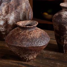 two old vases sitting on top of a wooden table