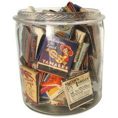 a glass jar filled with lots of different types of matchboxes on top of each other