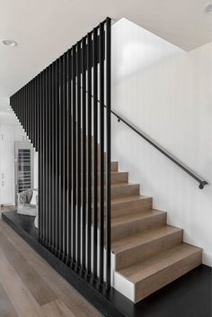 an iphone photo of a stair case in a house with white walls and wood floors