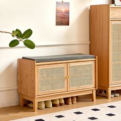 a wooden cabinet sitting next to a plant in a living room on top of a rug