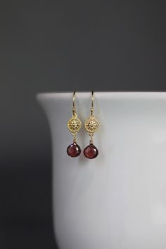 "Sweet micro faceted Red Garnet teardrops are wire wrapped with 14k gold filled wire onto bright 24k gold vermeil flower links.  These dangle from gold vermeil earwires. Choose from 18k gold vermeil balled gold earwires (as shown and sent with stoppers for the ends of the wires) or plain 24k gold vermeil leverback earwires (these close in the back). Perfect petite, lightweight everyday earrings!  Each pair of stones will vary slightly.  Gold flower link: 7x10mm Garnet teardrops: 7x7mm Total length of earrings: 1 1/4\" Length is approximate As the owner, maker, designer, and curator of this shop, I take great pride in providing you with jewelry that you will love to wear everyday, for special occasions, and for many years to come.  Please read my Shop Policies which contains important infor Gold Vintage Earrings, Red And Gold Earrings, Garnet Teardrop Earrings, Gold Wire Wrapped Earrings, Red Garnet Jewelry, Flower Earrings Gold, Gemstone Earrings Gold, Pretty Jewelry Necklaces, Garnet And Gold