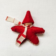 an ornament made to look like a star with a red hat and scarf