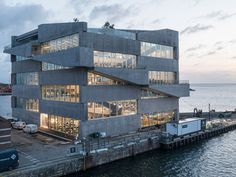 a large building sitting on the side of a body of water next to a dock