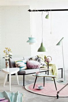 a living room filled with lots of furniture next to a wall covered in white tiles