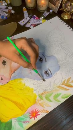 a person is drawing on a sheet of paper with colored pencils and watercolor pens