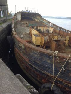 an old wooden boat sitting in the water