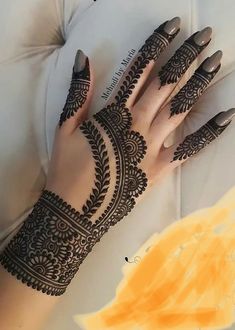 a woman's hand with henna on it and her hands painted in black