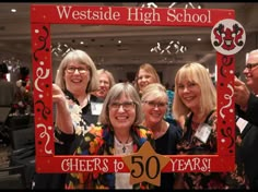 some people are posing for a picture in front of a sign that says, westside high school cheers to 50 years