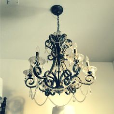 a chandelier hanging from the ceiling in a room with white walls and flooring