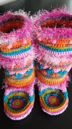 crocheted baby booties with colorful yarns on them