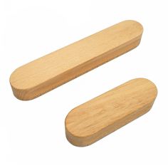 two wooden pegs sitting next to each other on a white surface