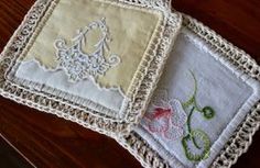 three embroidered coasters on a wooden table with crocheted edges and lace trim